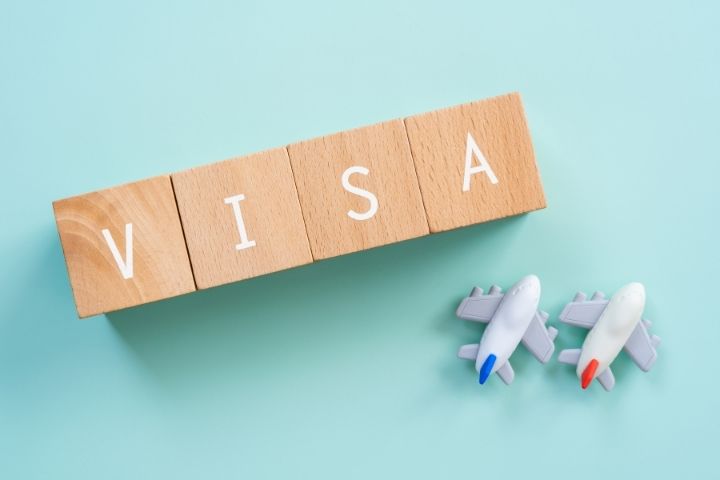 VISAと書かれた木のブロックと飛行機の置物の画像