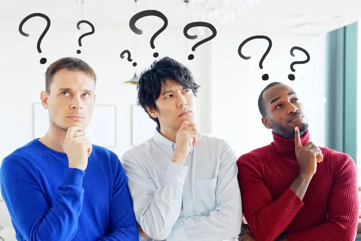 いろいろな国籍の男性3人が疑問に抱いている様子の画像
