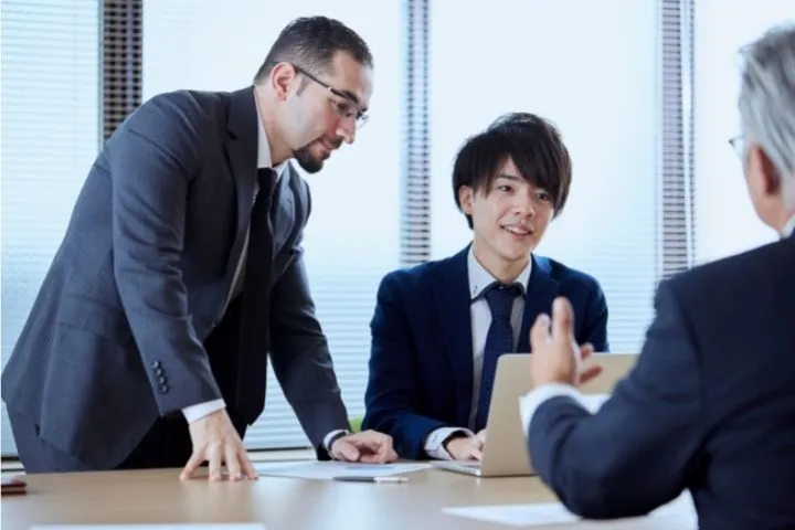 外国人と働く日本人男性の画像