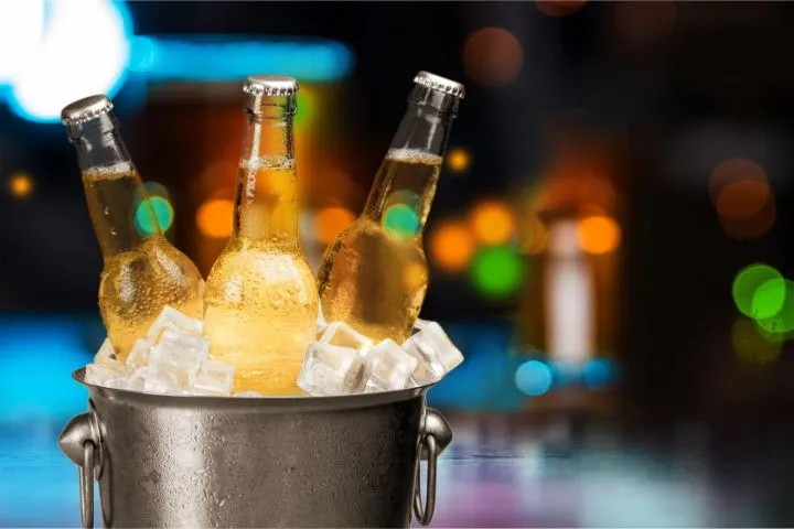 ビール瓶3本が氷バケツで冷やされている画像