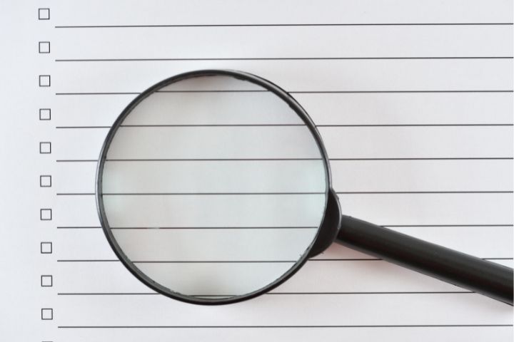 虫眼鏡とノートの画像
