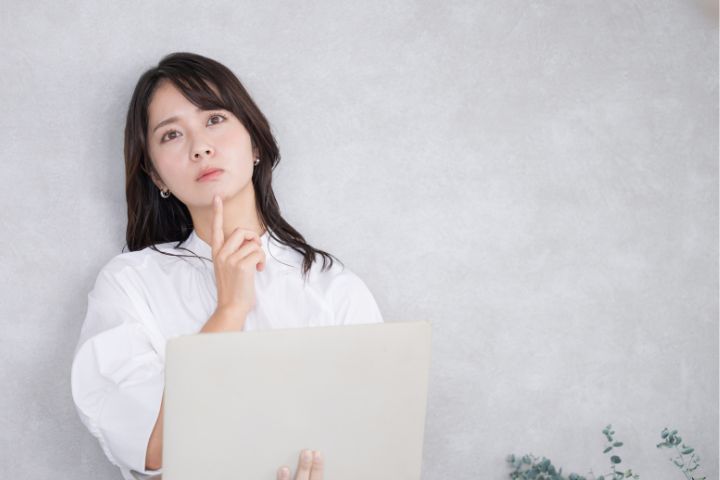 考える女子大学生の画像