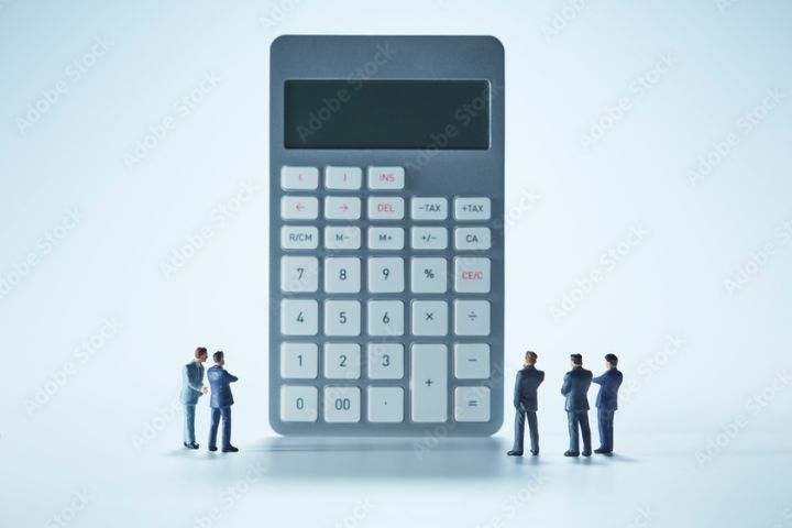 計算機とミニチュアのサラリーマンの画像