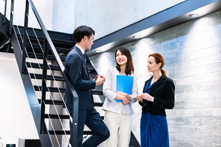 海外のオフィスで会話する日本人ビジネスマンのイメージ