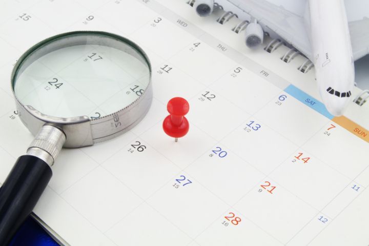 カレンダーと虫眼鏡と飛行機の模型の画像