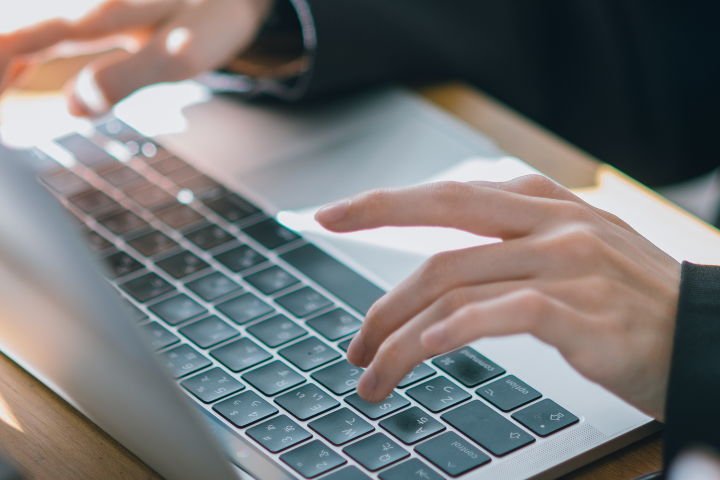 ノートパソコンでタイピングする手元