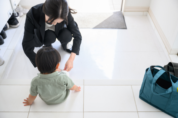 玄関で子供に靴を履かせるワーキングママのイメージ