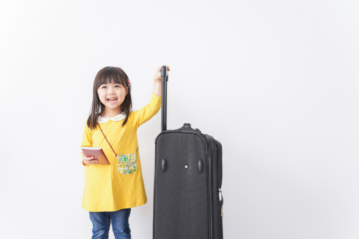 スーツケースとパスポートを持つ女の子の画像