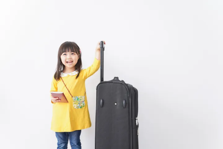スーツケースとパスポートを持つ女の子の画像