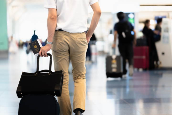 空港でスーツケースを持ち歩く男性のイメージ