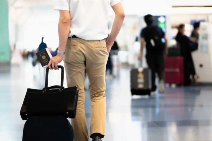 空港でスーツケースを持ち歩く男性のイメージ