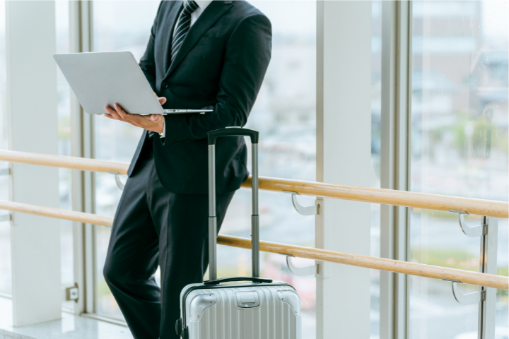 空港の窓際でパソコン作業している男性のイメージ