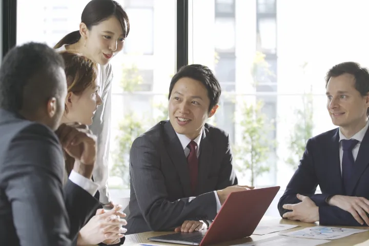グローバルオフィスで会議をしている人たちのイメージ
