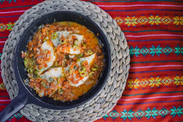 メキシコ・ベラクルスの代表的な料理ペスカード・ア・ラ・ベラクルサーナ（白身魚のトマト煮込み）の画像