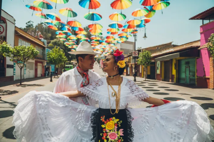カラフルな傘の下で笑顔のメキシコ人の男女の画像