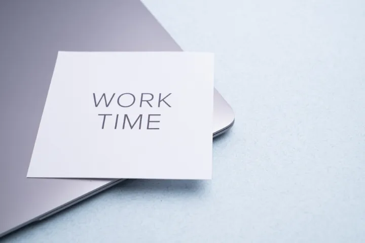WORK TIMEと書かれた紙とノートパソコンの画像