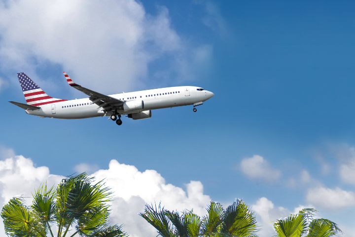 アメリカ国旗が描かれた飛行機が空を飛んでいる画像