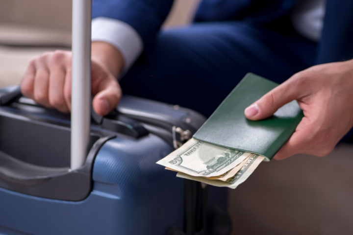 スーツケースとアメリカ紙幣の画像