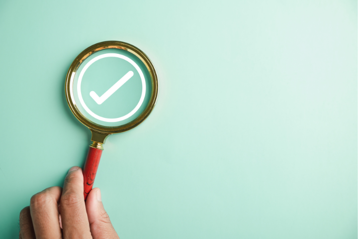 虫眼鏡で確認する手の画像