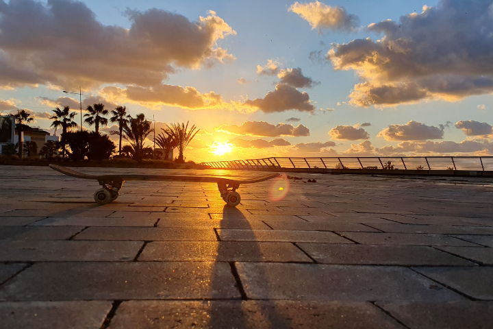 夕焼けのビーチとスケートボードのイメージ