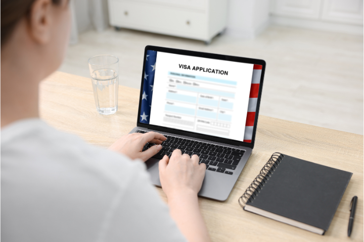 PCでビザ申請をしている女性のイメージ