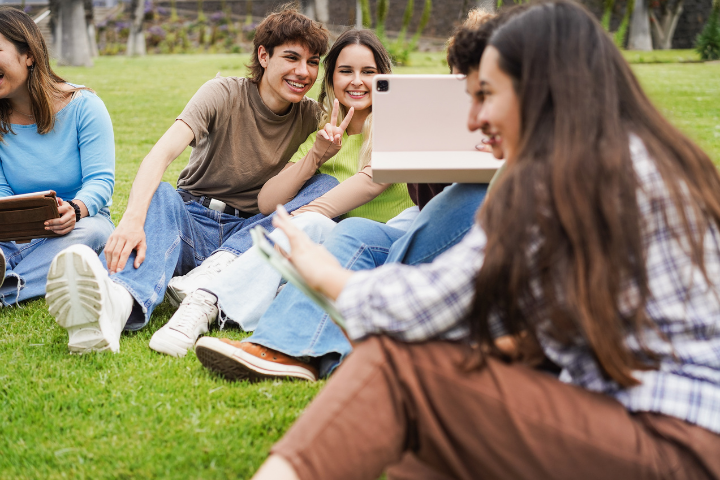 パソコンを見ながら談笑する若い男女の集団