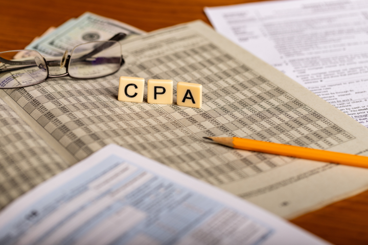 メガネ、お金、公認会計士、鉛筆が描かれた税務申告書のコンセプトイメージ