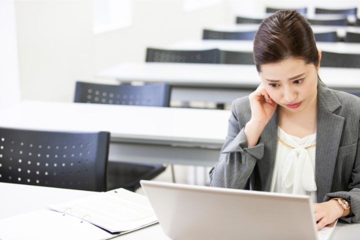 PCを開き試験を受けている女性の画像